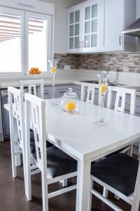 奥萨德蒙铁尔Casa Rural Los Eneares的白色的厨房配有白色的桌子和椅子