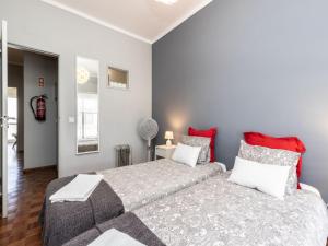 法鲁阿齐索尔法鲁阳光公寓的一间卧室配有大床和红色枕头