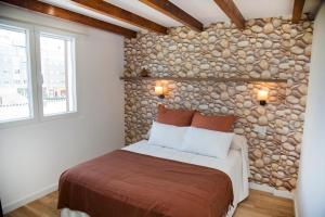 阿丰萨格拉达卡萨马诺洛旅馆的一间卧室配有一张石墙床