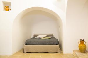 阿尔贝罗贝洛Il Trullo del viaggiatore的一间白色客房内的床铺卧室