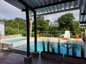 金巴亚Casa de Campo Las Partidas的一座带凉亭的游泳池,位于一座房子旁边