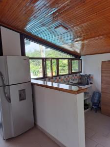 金巴亚Casa de Campo Las Partidas的厨房配有白色冰箱和木制天花板