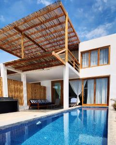卡诺阿斯德蓬萨尔Casa GAIA - Punta Sal的一座带游泳池和木制凉亭的房子