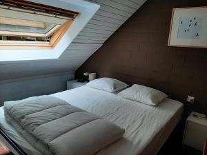 胡塔伦De Bosdreef - Hengelhoef - duplex met verwarmd openluchtzwembad的卧室内的一张带白色床单和枕头的床