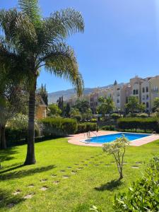 圣乌尔苏拉La Quinta Paradise的棕榈树公园和游泳池