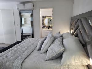 麦德林Hotel Hostal Caps El Poblado的卧室配有一张带灰色枕头的大床