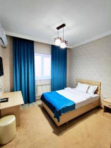 努库斯Asem Hotel的一间卧室配有一张带蓝色窗帘的大床