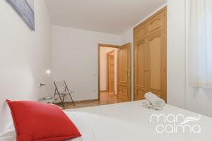 托里代巴拉Casa Bernat by MarCalma的卧室配有白色的床和红色椅子