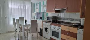 卡沃内拉斯Apartamento Nautilus Playa的厨房配有桌椅和微波炉。