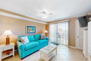 大洋城Makai 403的客厅配有蓝色的沙发和平面电视。