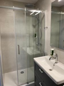 菲拉赫Motel55 - nettes Hotel mit Self Check-In in Villach, Warmbad的一间带玻璃淋浴和水槽的浴室