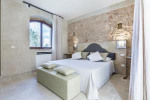 诺托Casa Vendicari Boutique Hotel的一间卧室设有一张大床和石墙