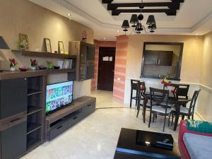 马拉喀什Appartements Marrakech Garden的带电视的客厅和用餐室