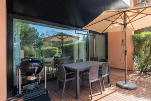 特罗亚Tróia Resort Beach Villa的一个带烧烤架和桌椅的庭院