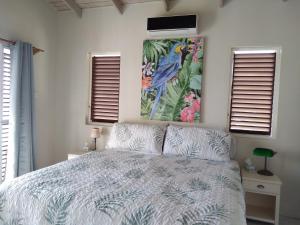 卡斯特里Seascape Villa 3BR with Stunning Caribbean Sea View的卧室配有一张床,墙上挂有绘画作品