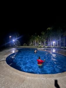 圣玛尔塔Finca San José los Naranjos的夜间在游泳池里的人
