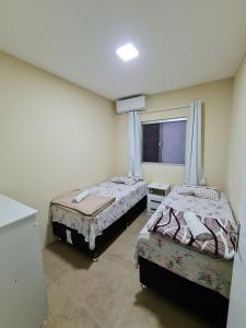 佩尼亚Ipê Eco Village的一间卧室设有两张床和窗户。