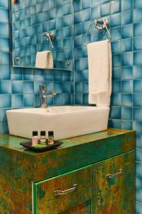 瑞诗凯诗Rajaji Delight, Rajaji National Park, Rishikesh的浴室配有水槽和蓝色瓷砖墙壁。