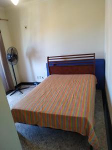 萨夸雷马Apartamento charmoso的一间卧室配有一张带条纹床罩的床