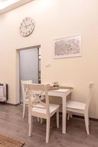 布达佩斯Goldcentral Apartment Comfort的一间带桌椅和时钟的用餐室