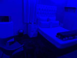 奥克尼Colins Accommodation - DAYREST from R120 OVERNIGHT from R300的一间暗室,配有蓝色灯光床