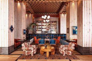 奥斯汀Austin Proper Hotel, a Member of Design Hotels的大堂设有带椅子和桌子的酒吧
