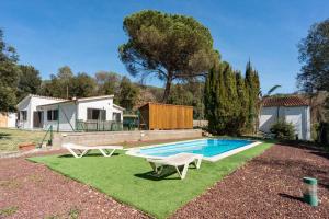 赫罗纳Casa con piscina cerca de Girona的一个带两把椅子和一张桌子的游泳池