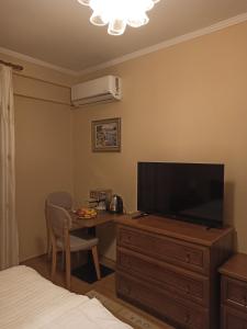 地拉那Home Sweet Rental的一间卧室配有带电视的梳妆台和带电视的书桌