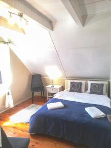 什奇特诺Wałpusz Holiday Home的一间卧室配有一张带蓝色毯子和椅子的床