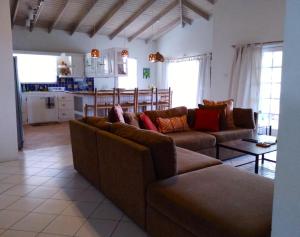 卡斯特里Seascape Villa 3BR with Stunning Caribbean Sea View的一间带2张棕色沙发的客厅和一间厨房