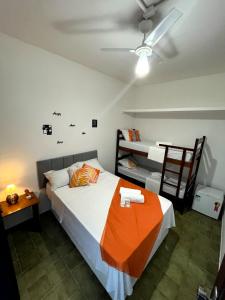 乌巴图巴Pousada Tribo Ubatuba的一间卧室配有一张带橙色毯子的床