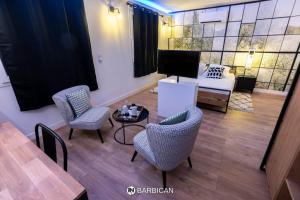 维拉尔雷东布Barbican的客厅配有椅子、桌子和沙发
