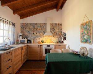 楼尔Cosy Farmhouse Quinta da Eira 140 years old的厨房配有木制橱柜和绿桌。