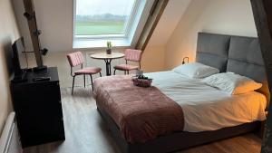 NoordbeemsterVakantieboerderij Huize Nuis的卧室配有一张床和一张桌子及椅子