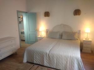 塔维拉Casa 16的卧室配有白色的床和两盏灯。