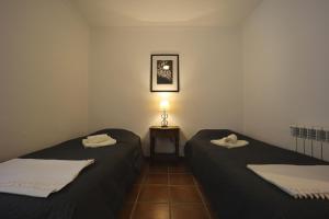 松塞尔韦拉Chalet Tres Mares, Cala Millor的客房设有两张床和一张带台灯的桌子。
