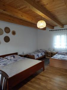 斯诺基Sobe Ivan Rastoke 21的一间卧室设有两张床和木制天花板