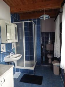 斯诺基Sobe Ivan Rastoke 21的蓝色瓷砖浴室配有淋浴和盥洗盆