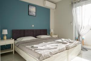马斯蒂查里Amvrosia Apartments的一间卧室配有一张带蓝色墙壁的大床