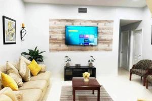 迈阿密Amazing & cozy Duplex near Zoo Miami !的客厅配有沙发和墙上的电视