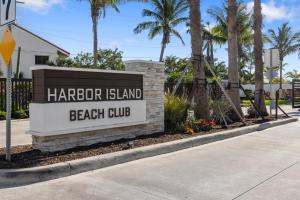 墨尔本比奇Villatel at Harbor Island Beach Club的棕榈树海滩俱乐部的标志