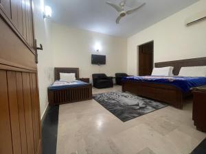 伊斯兰堡Dream Palace的客房设有两张床、一把椅子和电视。