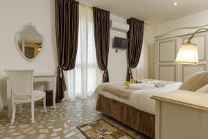 比萨Da Rita Affittacamere的酒店客房带一张床、一张书桌和一面镜子