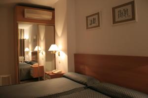卡莱塔德贝莱斯阿尔帕莱索酒店的酒店客房,配有床和镜子