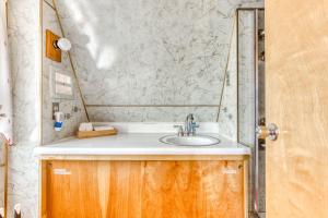 韦尔奇Chalet Shangri-La的一间带水槽和大理石墙的浴室