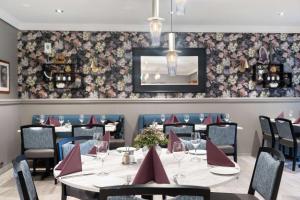 康斯博基登拉弗贝斯特韦斯特优质酒店的用餐室配有桌椅和花卉壁纸