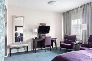 康斯博基登拉弗贝斯特韦斯特优质酒店的酒店客房配有一张床和一张带紫色椅子的书桌