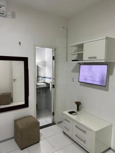 圣阿马鲁Eco House Gaivota - Cond Ville Portal das Dunas的白色的客厅配有电视和椅子
