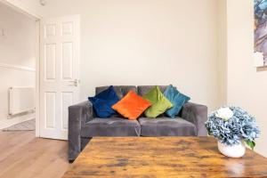 利物浦3-bedroom Home in Liverpool L15 with FREE Parking的客厅配有带色彩缤纷枕头的沙发