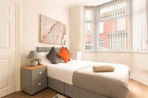 利物浦3-bedroom Home in Liverpool L15 with FREE Parking的一间卧室配有一张带橙色枕头的床